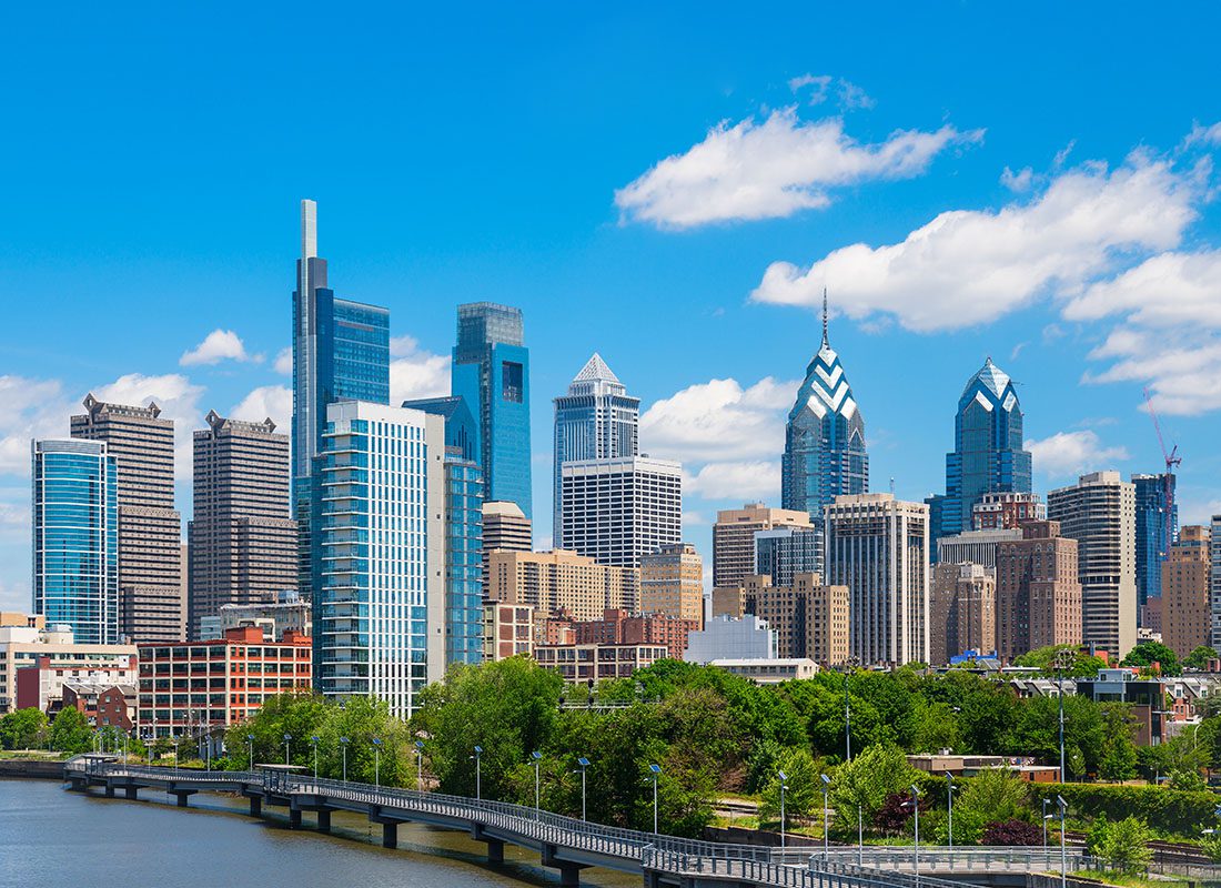 Contact - View of Commercial Buildings and Skyscrapers Against a Cloudy Blue Sky in Downtown Philadelphia Pennsylvania